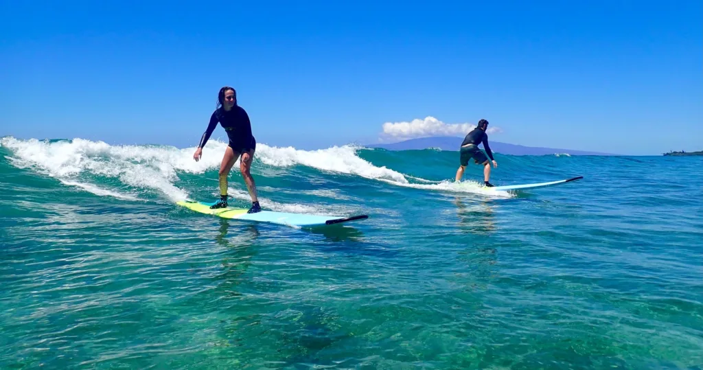 Instructor giving semi-private surf lesson to two students