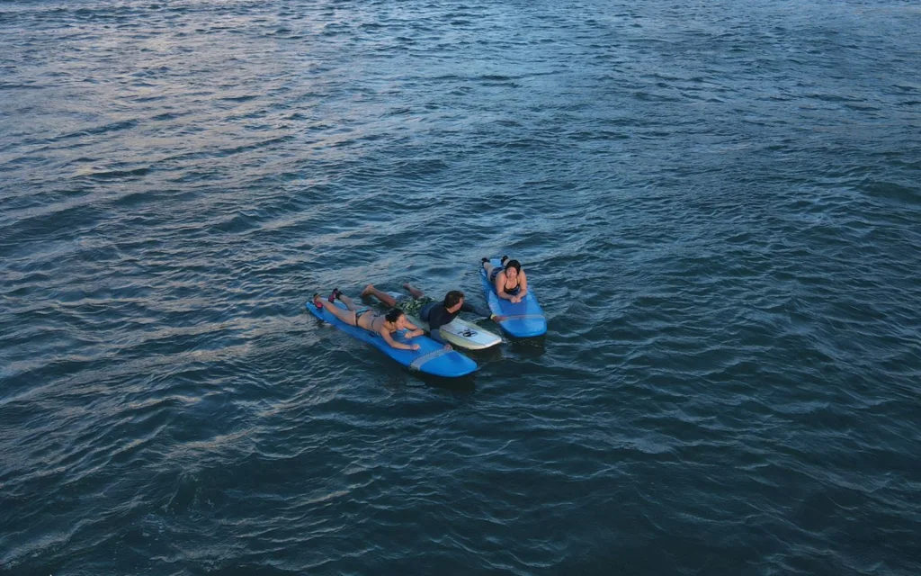 Small group of three taking a private surf lesson together