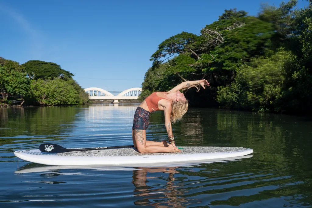 Group practicing yoga on paddleboards in calm water