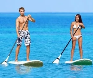 Paddleboard resting on calm water near tropical beach