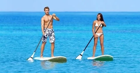 Paddleboard resting on calm water near tropical beach
