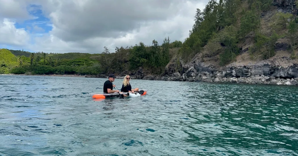 Clear bottom kayak floating over vibrant coral reefs in Maui