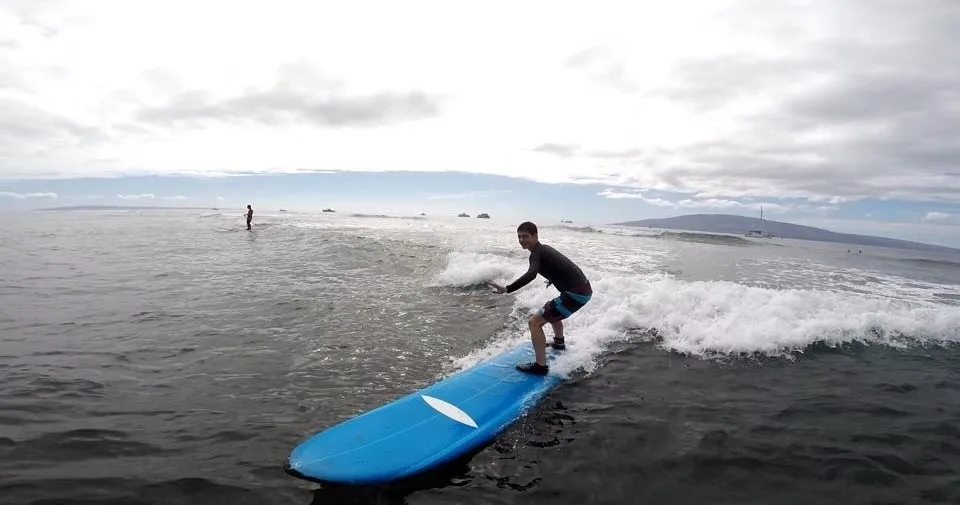 Instructor giving private surf lesson on Maui beach