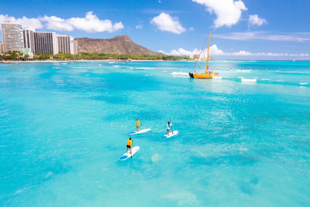 Small group paddleboarding together on calm ocean waters