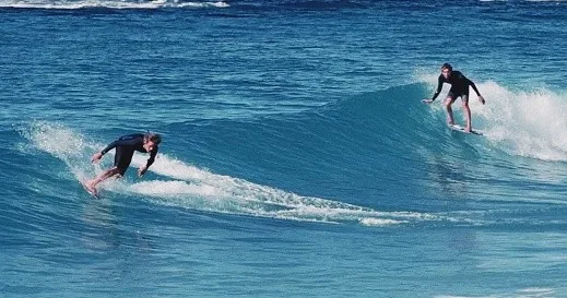 Group learning to skimboard together on a sandy beach