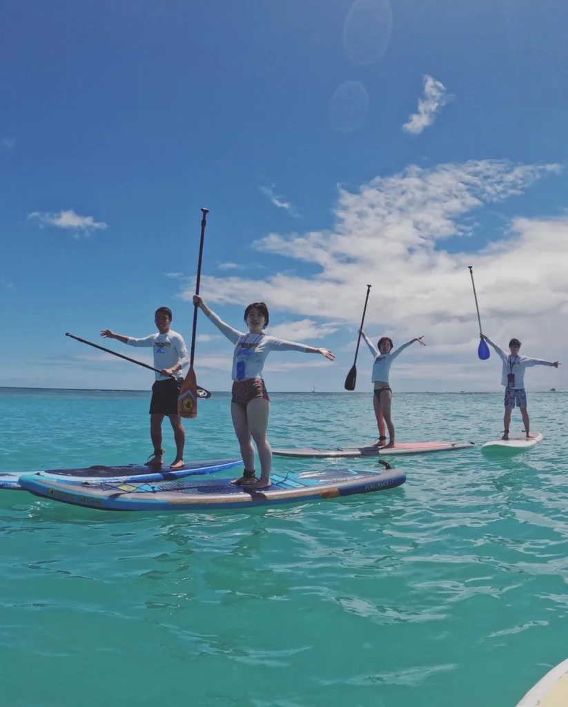 Participants learning stand-up paddleboarding in group lesson