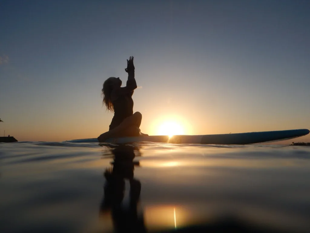 Yoga session on paddleboard during vibrant sunset