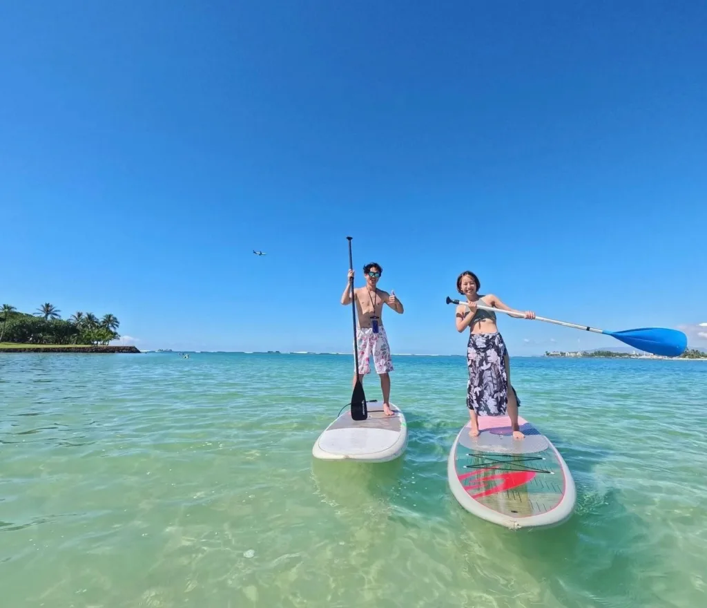 Participants learning stand-up paddleboarding in small group