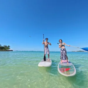 Participants learning stand-up paddleboarding in small group