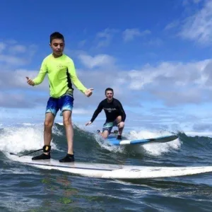 Surf class participants learning to ride waves on Maui beach