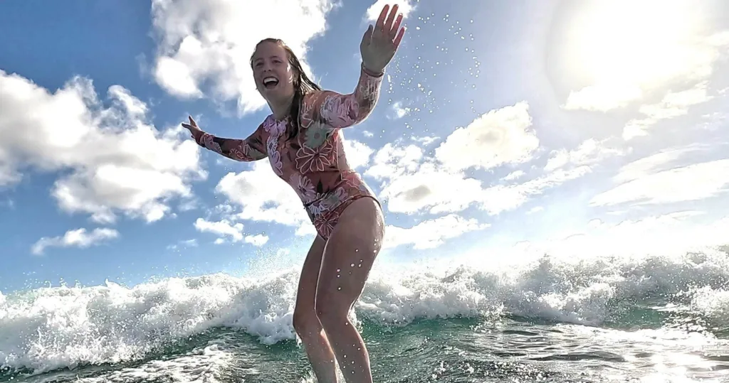 Instructor giving a private surf lesson on calm ocean waves