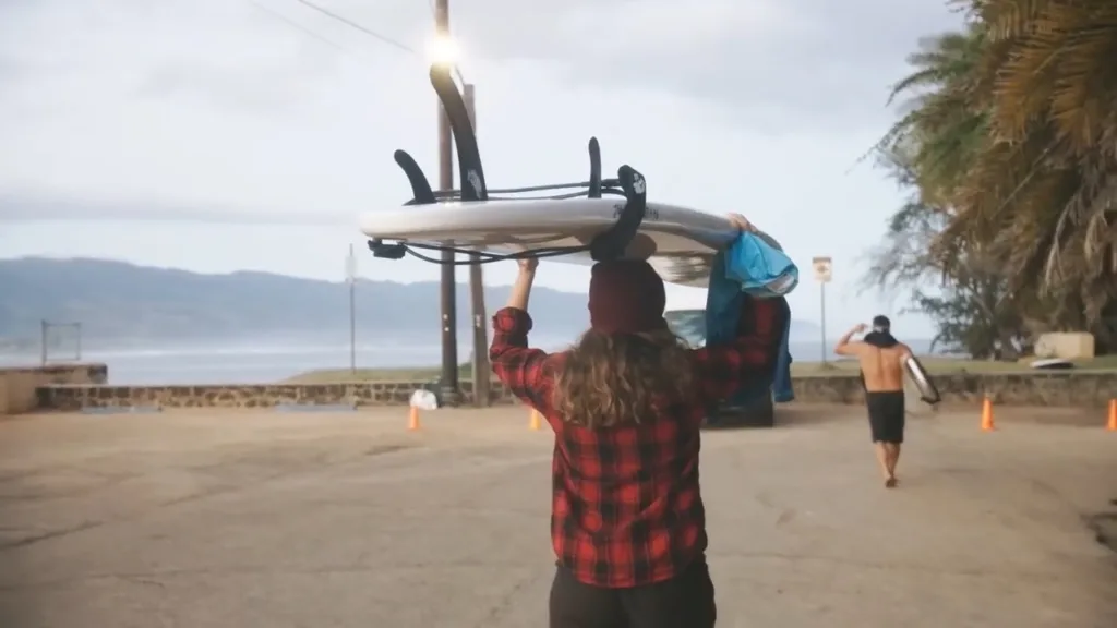 Surfboards and beach rentals lined up on sandy shore