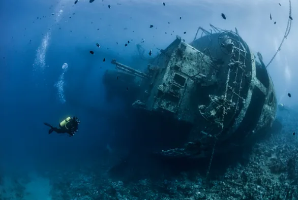 Scuba diver practicing skills underwater near coral reef