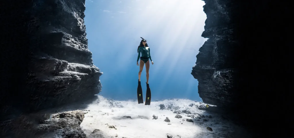 Scuba divers exploring underwater near Waikiki shore