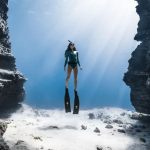 Scuba divers exploring underwater near Waikiki shore