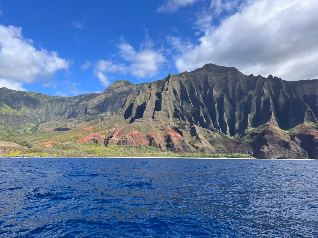 Boat cruising along the Na Pali Coast cliffs