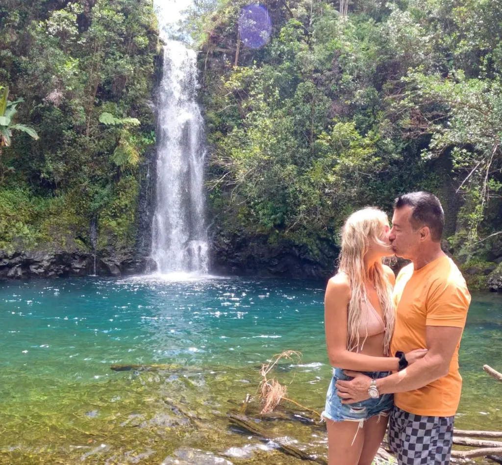 Hikers trekking along lush Hana trail through forest