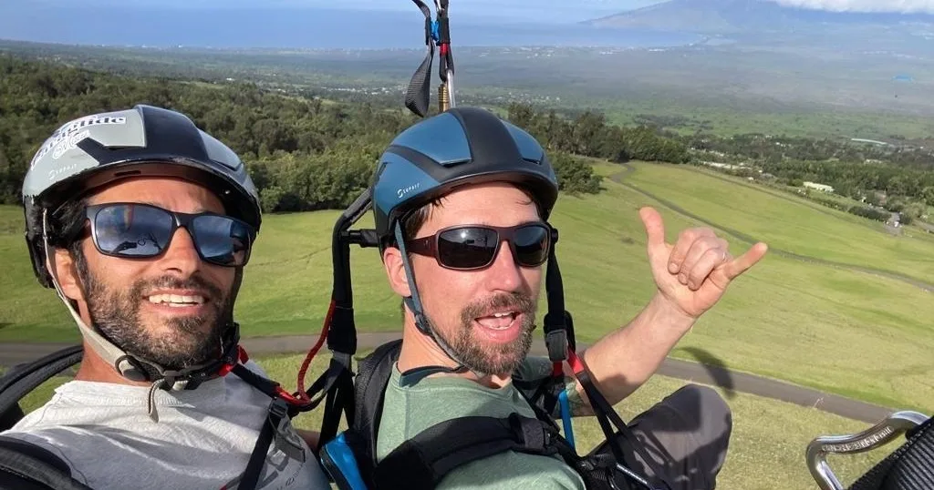 Tandem paragliders launching from mountain during flight