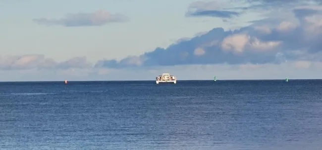 Power catamaran cruising at sunset on Big Island