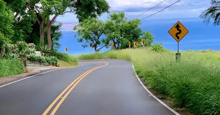 Cyclists riding along scenic Maui coastline on biking tour