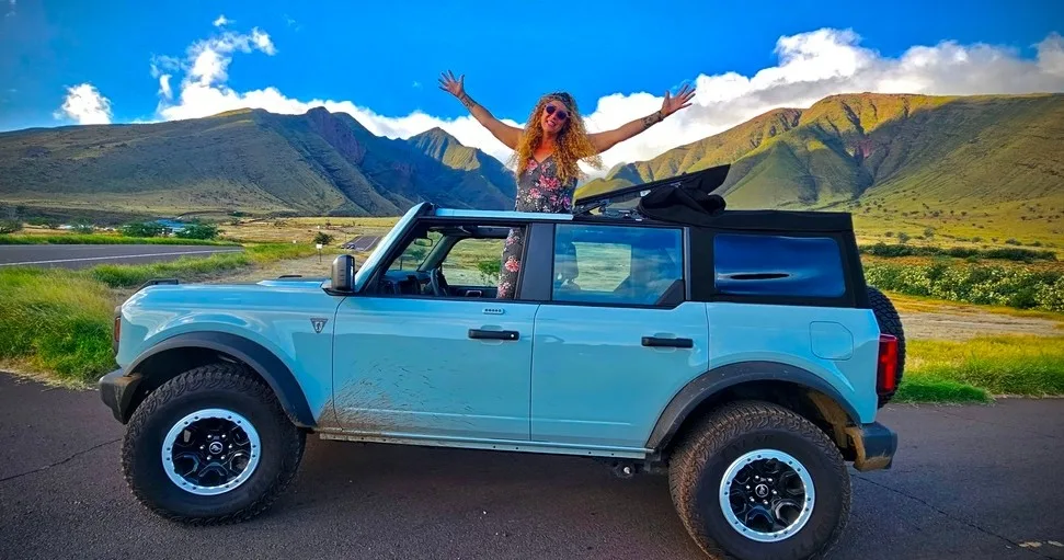 Convertible Bronco driving along Maui's scenic Hana road