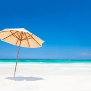 Beach umbrella shading two comfortable lounge chairs