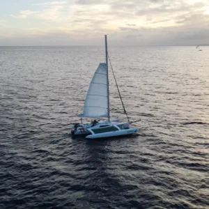 Sailboat gliding across calm waters at sunset in Waikiki