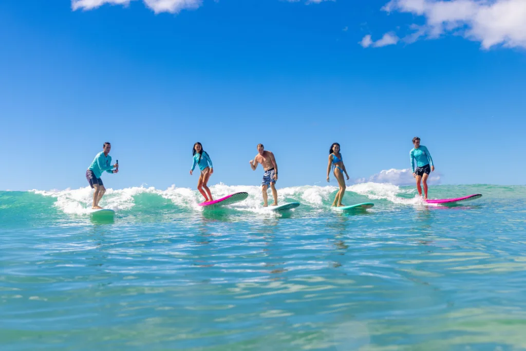 Family enjoying surfing lesson together on sandy beach