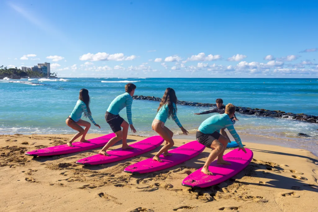 Large group learning to surf on sunny island beach