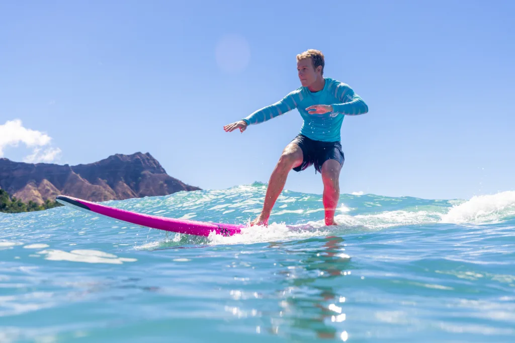 Individual receiving personalized surf coaching on calm beach