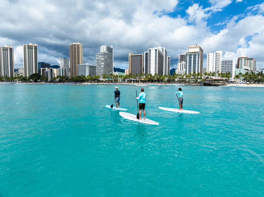 Family trying stand up paddleboarding in Waikiki waters