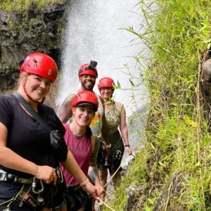 Group hiking adventure featuring waterfall rappelling activities