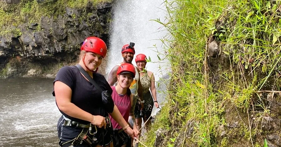Group hiking adventure featuring waterfall rappelling activities