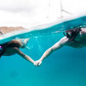 Couple snorkeling together in clear waters near Waikiki beach