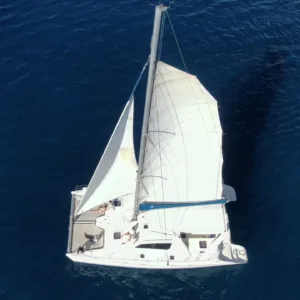 Private catamaran sailing at sunset on Artemis