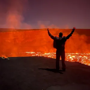 Hikers trekking volcanic landscape on Madam Pele’s trail