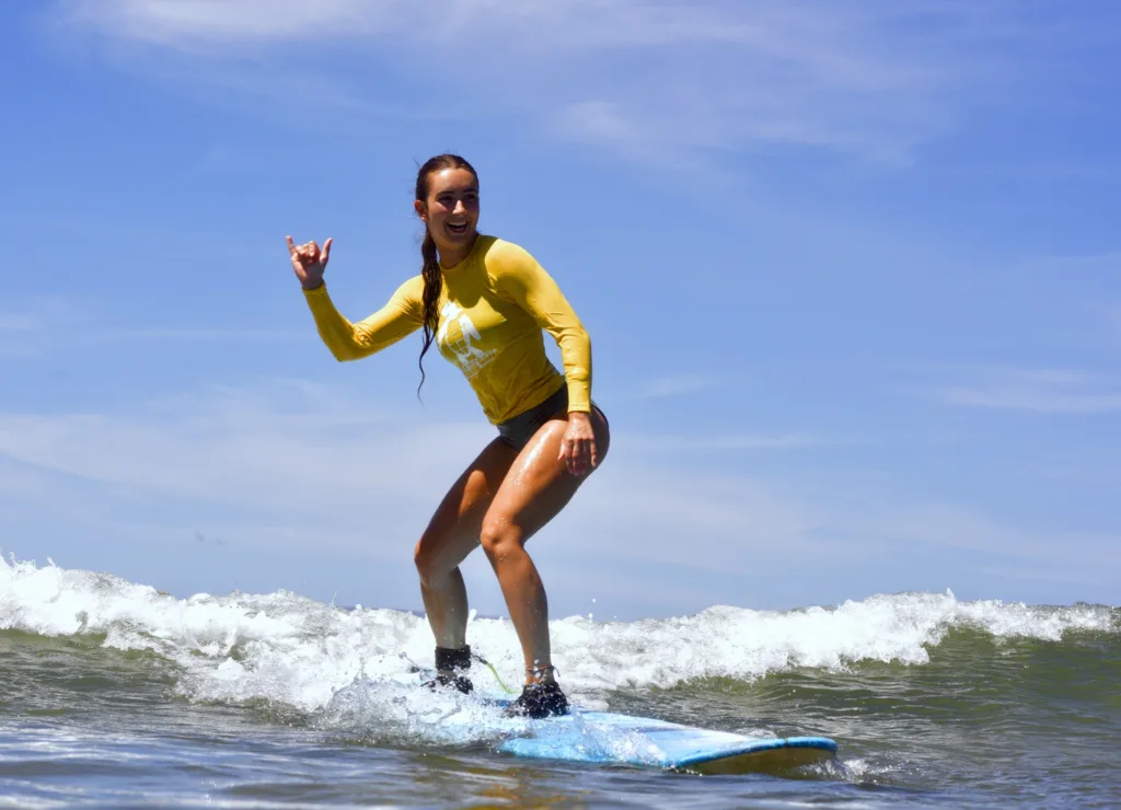 Surfing lesson with instructor guiding student on board