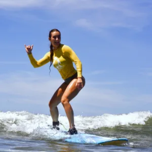 Surfing lesson with instructor guiding student on board