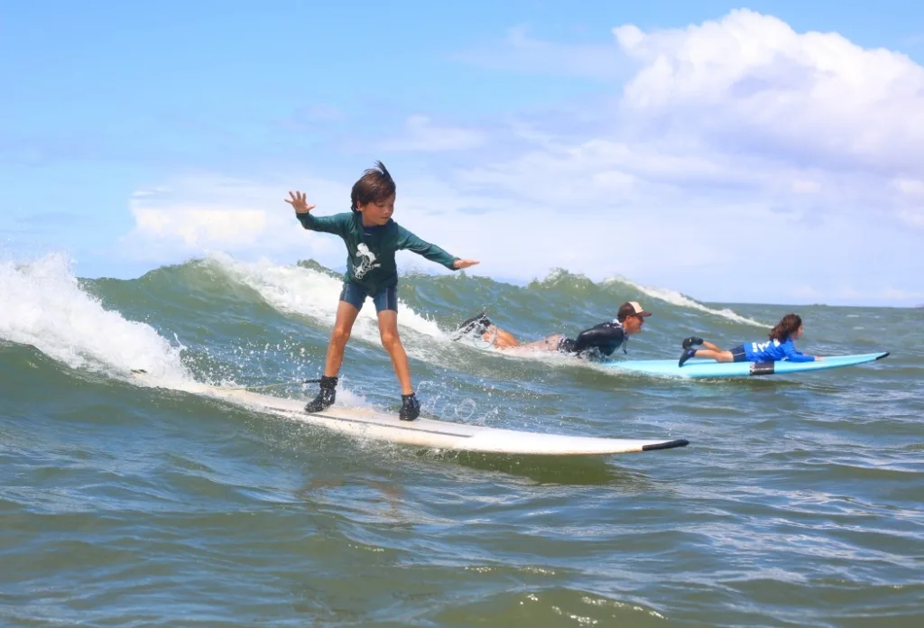 Children learning to surf in a fun island camp setting