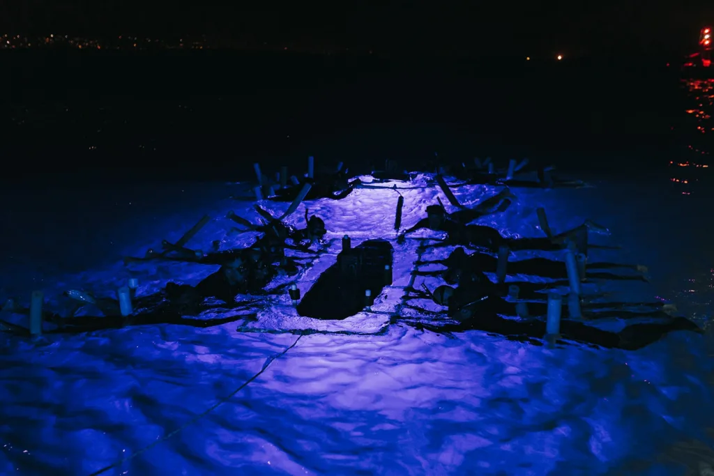 Night snorkelers observing graceful manta rays underwater at Kona