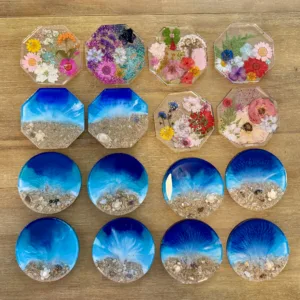 Hands creating epoxy resin coasters in art class
