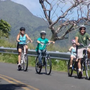 Cyclist riding downhill through lush Oahu mountain trails