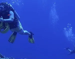 Scuba diver using underwater scooter to explore coral reefs