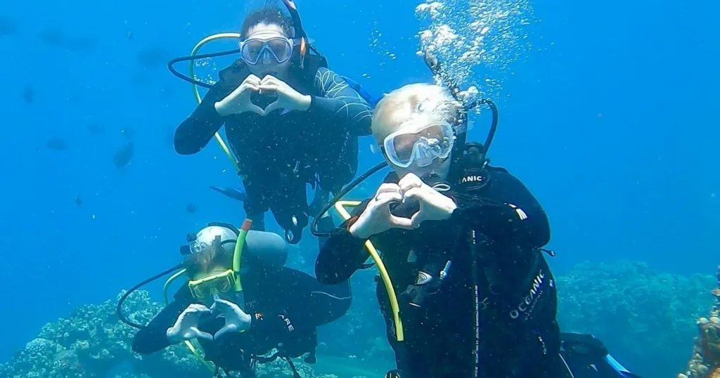 Beginner scuba diver trying on gear before first underwater dive