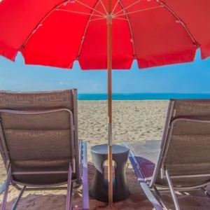 Pink beach umbrella sets arranged on sandy shore
