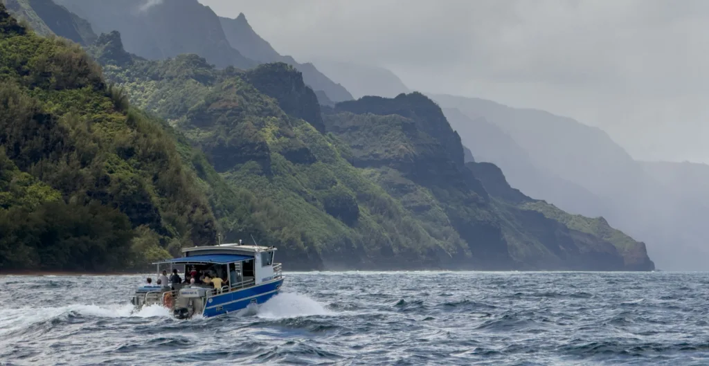 Boat cruising along Nā Pali Coast during winter morning