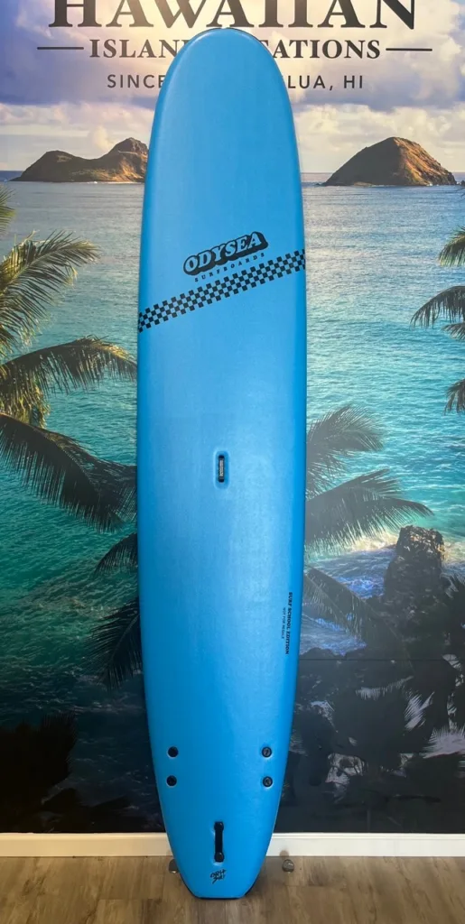 Blue 10 foot Odysea surfboard on shore at sunrise
