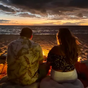 Campfire glowing under starry island night sky