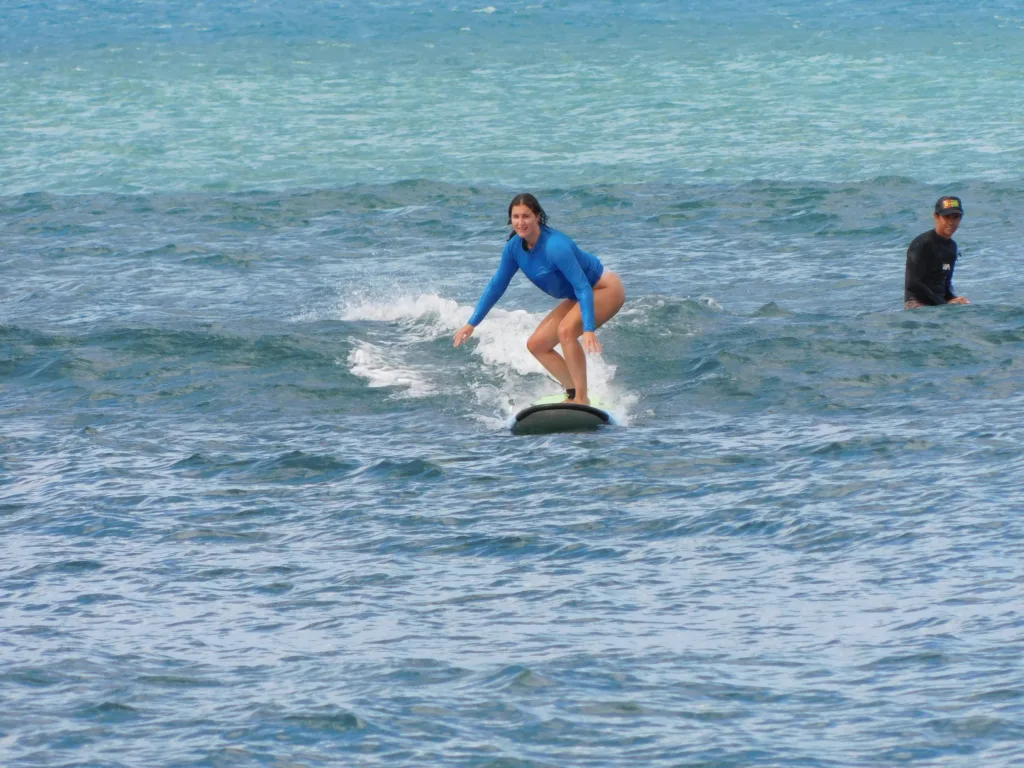 Instructor giving a private surf lesson on a sunny Hawaiian beach