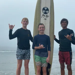 Instructor teaching a small group how to surf on waves